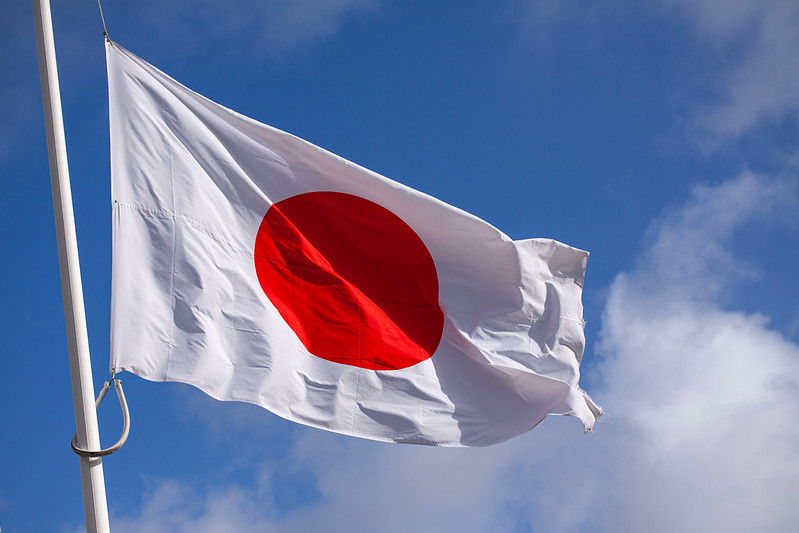 Japan flag waving in the wind against blue sky